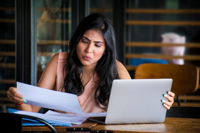 Shopifyの料金プラン4種を比較検討するノートパソコンと資料のデスクイメージ